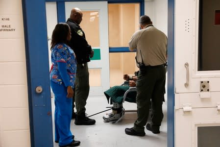 An inmate on suicide watch sits while prison officers talk to him at the Chatham County jail in Savannah