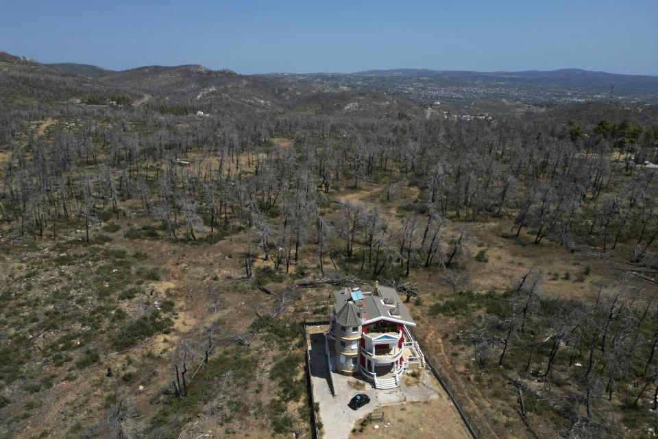 A house is seen in front of a forest which had been burned in an Aug. 2021 wildfire, in Ippokratios Politia village, about 35 kilometres (21 miles) north of Athens, Friday, Aug. 23, 2024. (AP Photo/Thanassis Stavrakis)