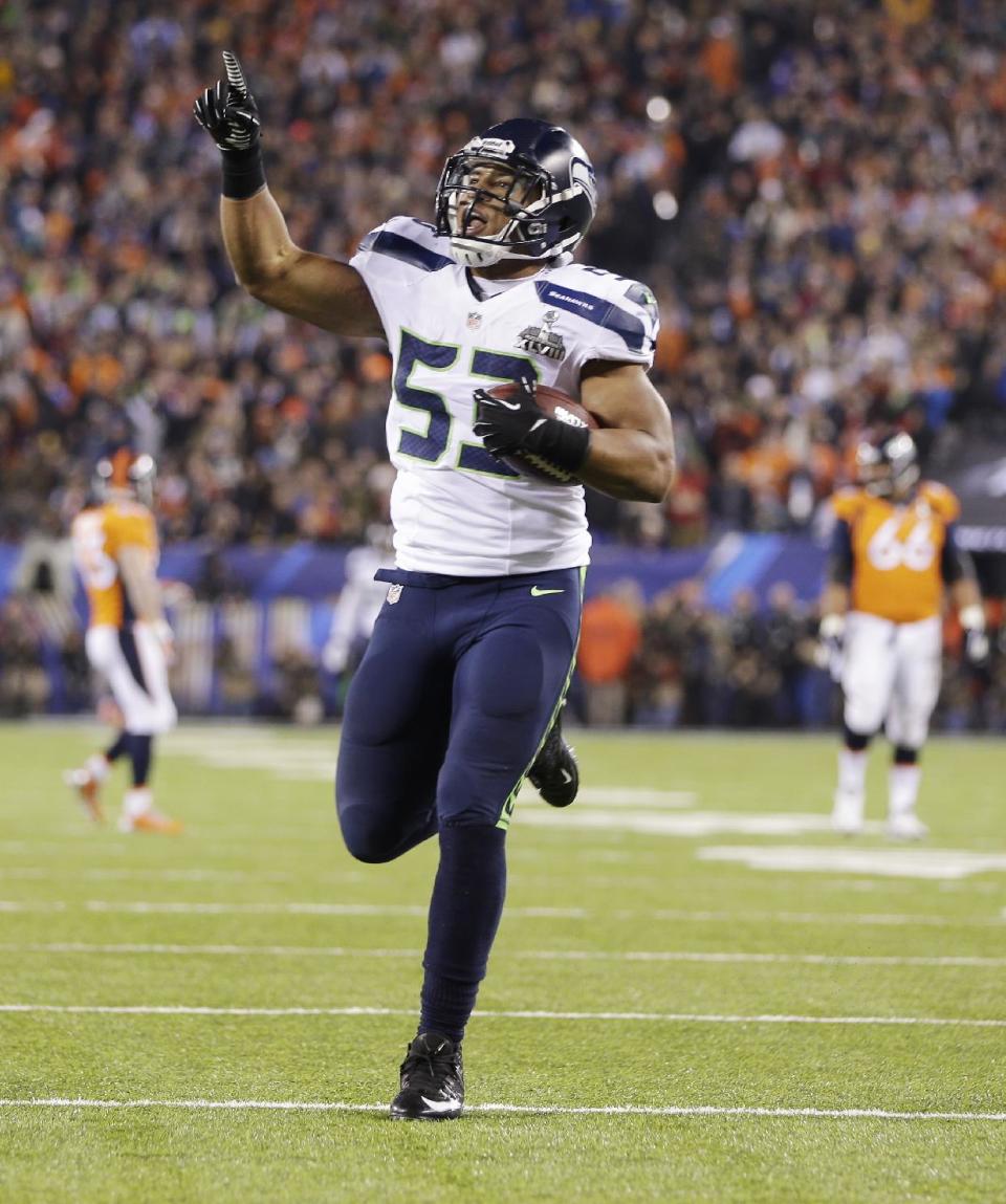 Seattle Seahawks' Malcolm Smith celebrates after scoring a touchdown on an interception during the first half of the NFL Super Bowl XLVIII football game Sunday, Feb. 2, 2014, in East Rutherford, N.J. (AP Photo/Mark Humphrey)