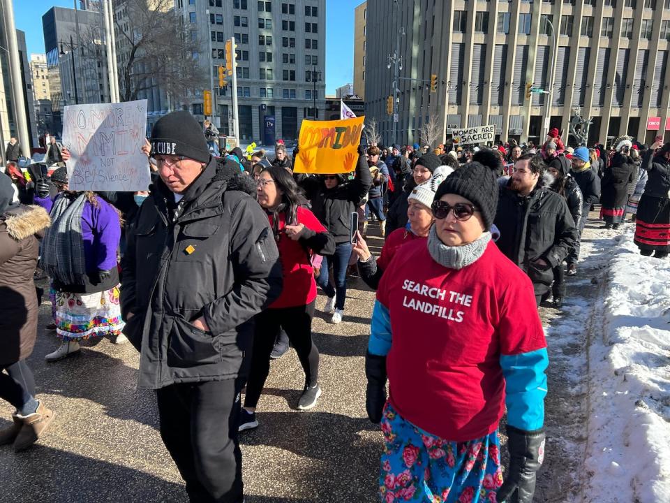 A crowd begins marching to the legislative building after a round dance at Portage and Main on Friday.