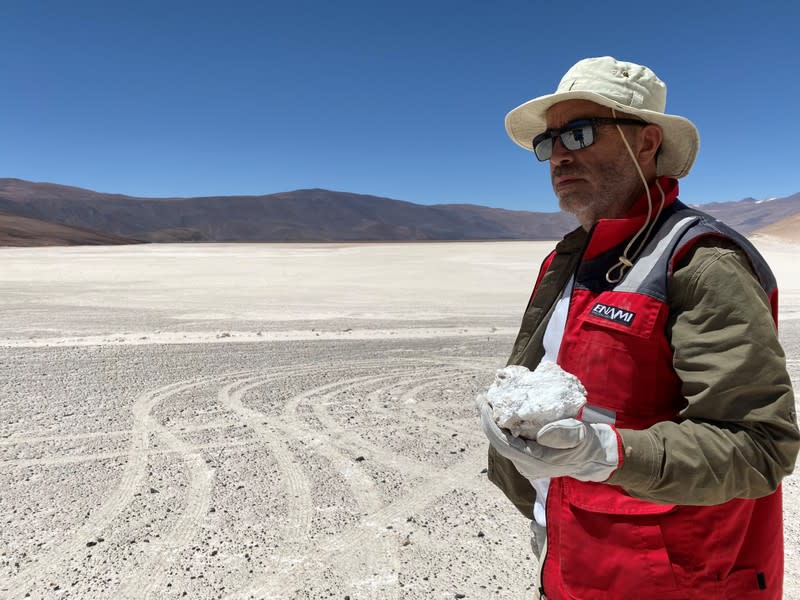 A worker holds an ore piece at Aguilar Salt Flat in the Atacama Desert