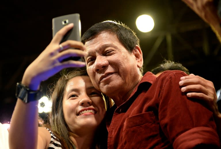 A supporter takes a selfie with presidential candidate Rodrigo Duterte at a rally in Manila on February 9, 2016