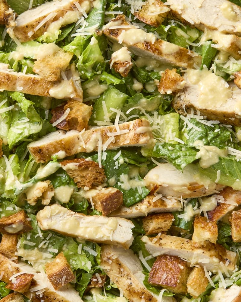 close up shot of chicken caesar salad topped with cheese