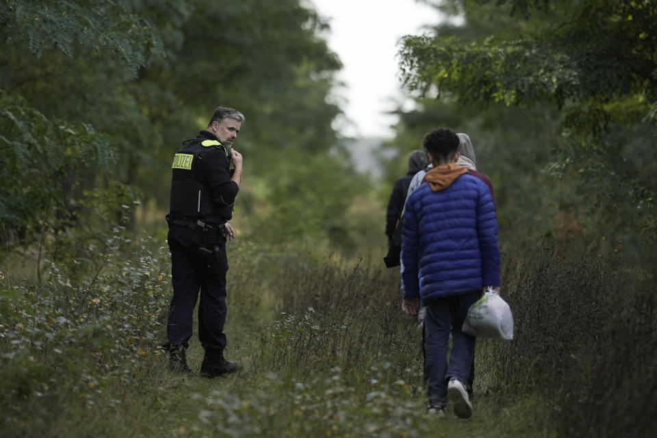 Federal Police officer Frank Malack escorts a group of migrants who illegally crossed the border from Poland into Germany during a patrol in a forest near Forst southeast of Berlin, Germany, Wednesday, Oct. 11, 2023. (AP Photo/Markus Schreiber)