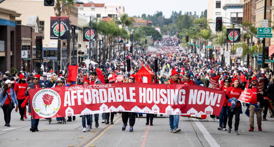 Protesters marching with a banner saying "Affordable Housing Now!"