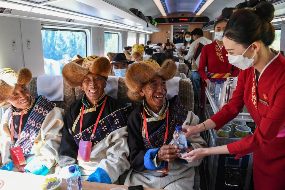 Staff members serve passengers refreshments on the Fuxing bullet train