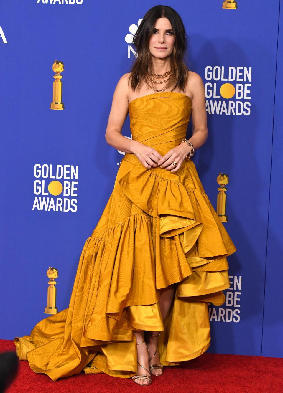 Sandra Bullock at the 2020 Golden Globes in a mustard colored ruffled gown