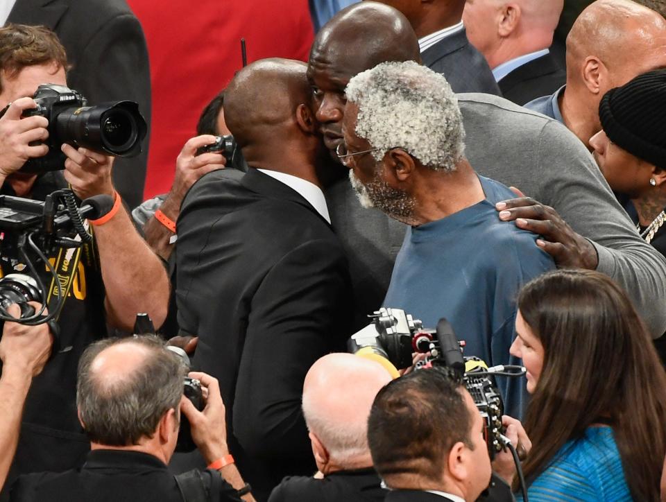 Kobe Bryant talks to Shaquille O'Neal and Bill Russell at the conclusion of a halftime ceremony to retire his two uniform numbers at Staples Center in 2017.