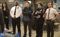 This image released by NBC shows the cast of the comedy series "Brooklyn Nine-Nine," from left, Stephanie Beatriz, Andre Braugher, Andy Samberg, Melissa Fumero and Joe Lo Truglio. In a world turned upside down by disease, TV viewership is growing. Actress Julie Bowen of “Modern Family” said she and her children binged on the NBC comedy, “Brooklyn Nine-Nine.”(Jordin Althaus/NBC via AP)