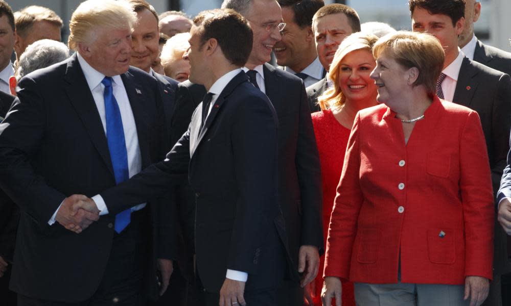 Angela Merkel watches as Donald Trump shakes hands with Emmanuel Macron in Brussels