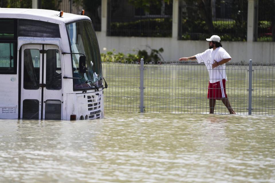 A man walks through floodwater in Dubai, United Arab Emirates, Wednesday, April 17, 2024 (AP)