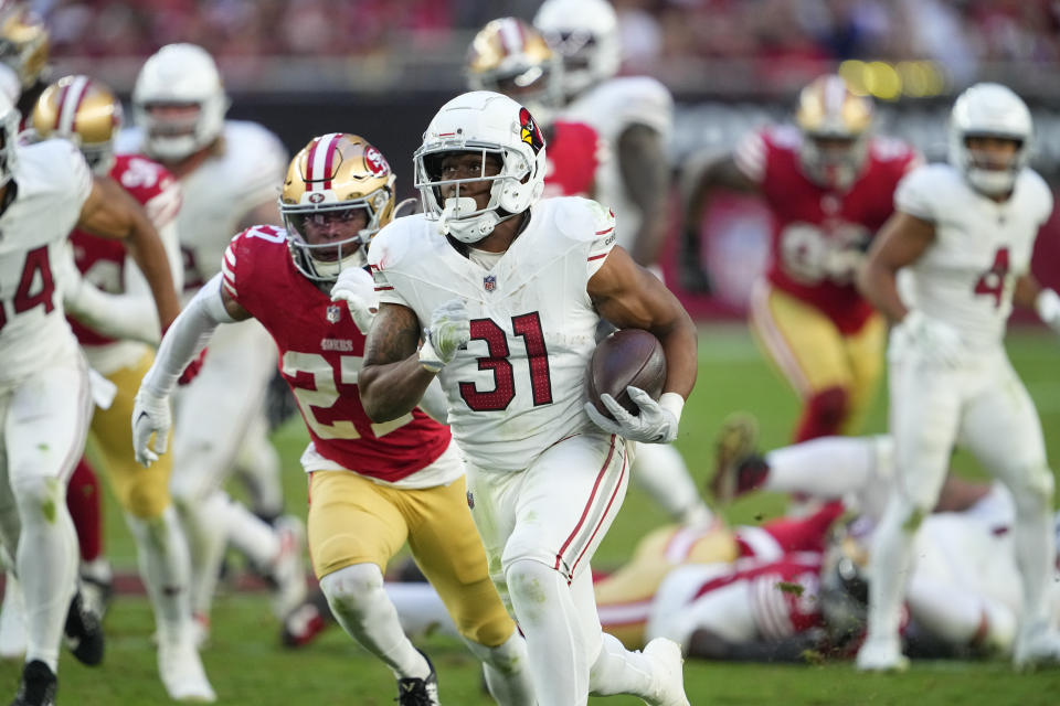 Arizona Cardinals running back Emari Demercado (31) runs for a touchdown in front of San Francisco 49ers safety Ji'Ayir Brown during the second half of an NFL football game Sunday, Dec. 17, 2023, in Glendale, Ariz. (AP Photo/Matt York)