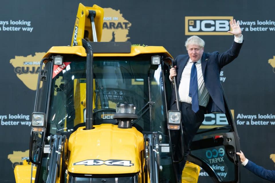 Prime Minister Boris Johnson climbs over a JCB at the new factory in Vadodara, Gujarat (Stefan Rousseau/PA) (PA Wire)