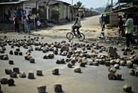 A man cycles past a barricade in Bujumbura on July 21, 2015, which was set up by protestors opposed to President Pierre Nkurunziza's bid for a third-term