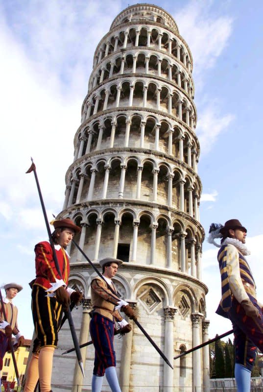 Honor guards in historical costumes pass by the Leaning Tower of Pisa on December 15, 2001, after the tower's re-opening to the public. File Photo by Franco Silvi/EPA/ANSA