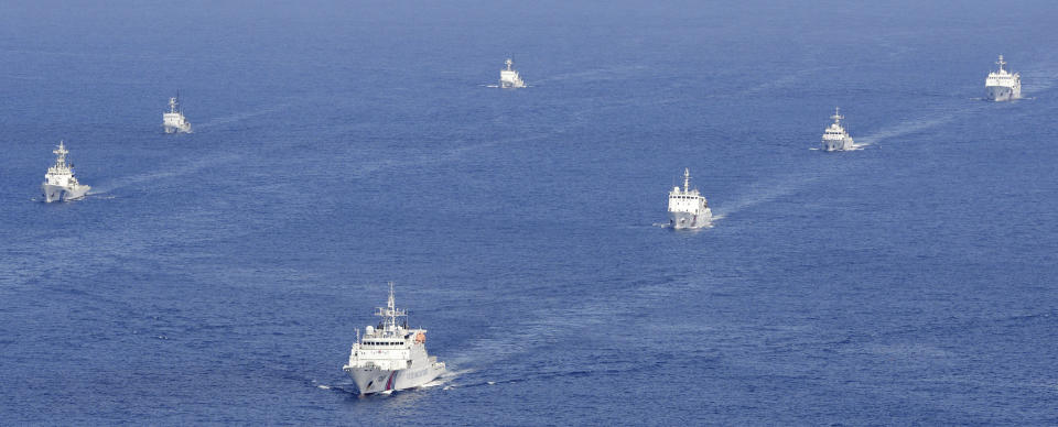 FILE - Four China coast guard vessels, right, are followed by Japan coast guard ships as they intruded into Japan's territorial waters near the disputed East China Sea islands called Senkaku by Japan and Diaoyu by China on Sept. 10, 2013. Japan adopted a new five-year ocean policy on Friday, April 28, 2023, that calls for stronger maritime security, including bolstering its coast guard's capability and cooperation with the military amid China’s increasing assertiveness in regional seas. (Kyodo News via AP, File)