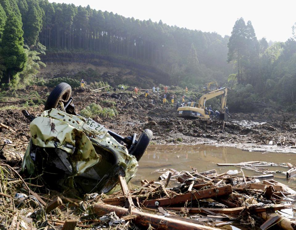 Rescue workers search for missing people at the scene of a landslide in Aso, Kumamoto Prefecture, Japan, Sunday, July 15, 2012. Heavy rain triggered flash floods and mudslides in southern Japan this week, killing about two dozens of people. (AP Photo/Kyodo News) JAPAN OUT, MANDATORY CREDIT, NO LICENSING IN JAPAN, CHINA, HONG KONG, SOUTH KOREA AND FRANCE