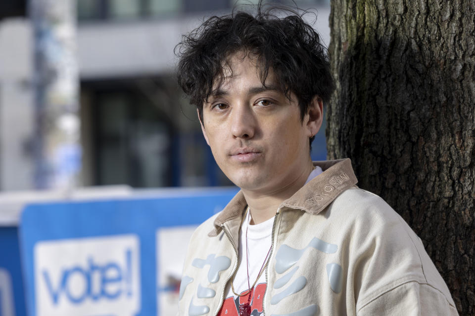 Kenji Takada-Dill, 30, of Seattle, poses for a photo next to a drop box where voters can drop off ballots in the vote-by-mail state Wednesday, March 13, 2024, in Seattle. (AP Photo/Jason Redmond)