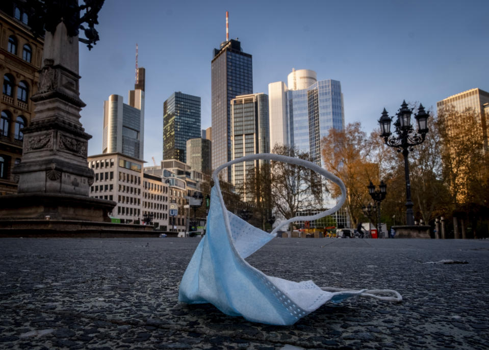 A face mask is left back on the opera square in Frankfurt, Germany, Saturday, April 24, 2021. From the weekend on a curfew becomes effective to avoid the outspread of the coronavirus. (AP Photo/Michael Probst)