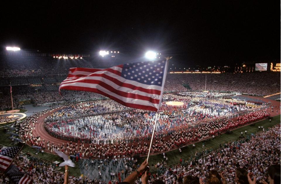 An American flag is waved during the Opening Ceremony of the 1996 Centennial Olympic Games at the Olympic Stadium in Atlanta, Georgia.