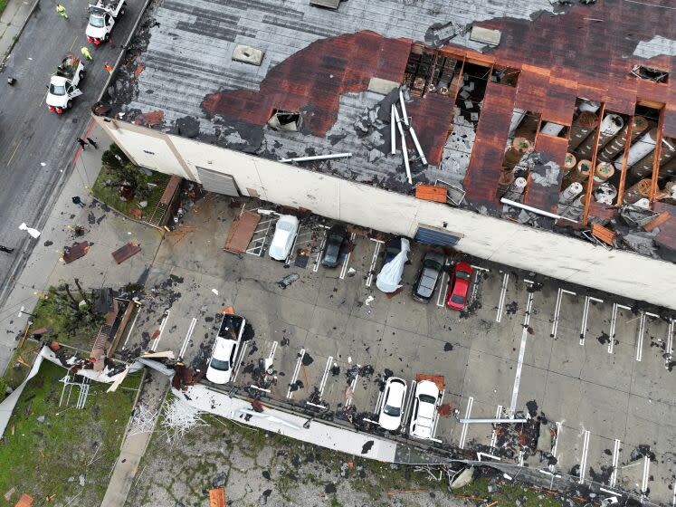 Montebello, CA - March 22: Crews start to clean up debris after a strong microburst -- which some witnesses dubbed a possible tornado -- heavily damaged several cars and buildings, including the roof of the Royal Paper Box Company, shown in photo, in Montebello Wednesday, March 22, 2023. Video from the scene showing portions of rooftops being ripped off industrial structures and debris swirling in the air. The National Weather Service on Tuesday night issued a brief tornado warning in southwestern Los Angeles County, but it was allowed to expire after about 15 minutes when weather conditions eased. There was no such warning in place late Wednesday morning when the powerful winds hit Montebello, near the area of Washington Boulevard and Vail Avenue. (Allen J. Schaben / Los Angeles Times)