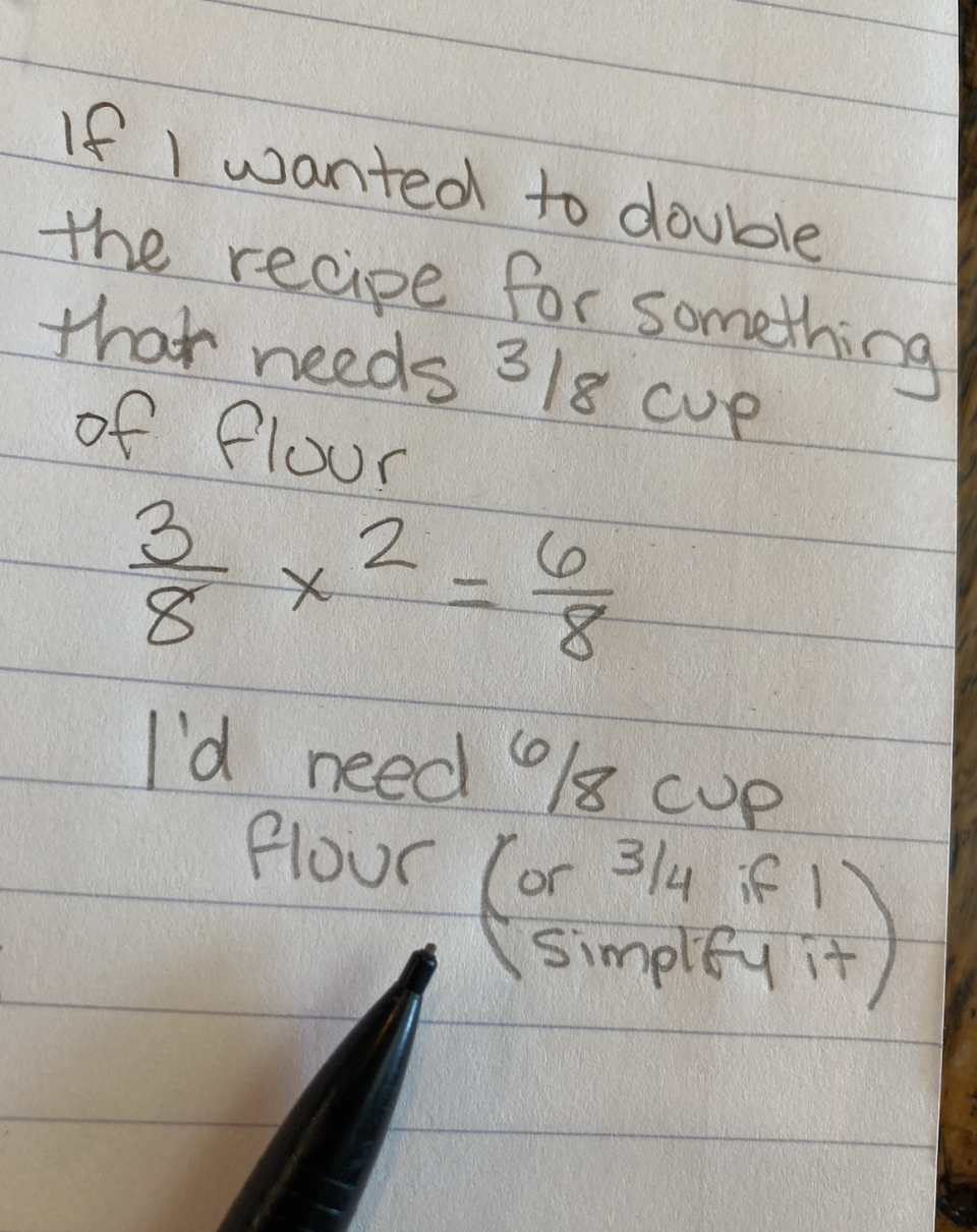 Handwritten note solving a math problem to double a recipe that requires 3/8 cup of flour, resulting in 6/8 cup or simplified to 3/4 cup