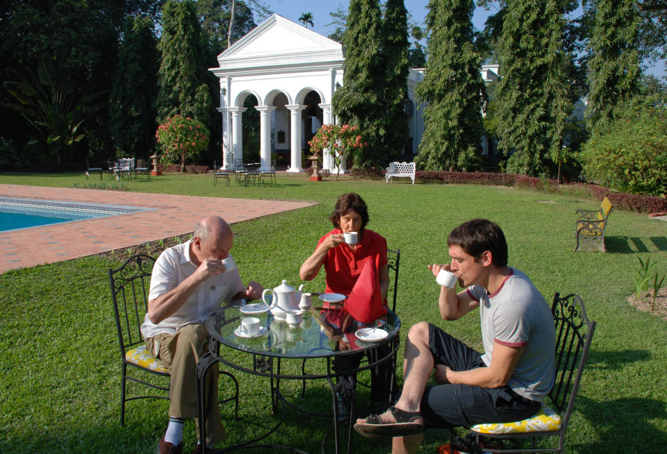 In this photo taken Nov. 29, 2012, people enjoy afternoon tea, a heritage from British colonial days, on the lawn of Thengal Manor in Jorhat, India. The manor was opened to guests in 2000 but is still owned by the third generation of the Barooah family, who grew rich planting tea and built the mansion in 1929. (AP Photo/Denis Gray)