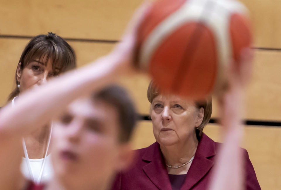 German Chancellor Angela Merkel, right, attends the training of the NINERS German first divisioner basketball youth teams (under 16 years and under 19 years) during her one-day visit in Chemnitz, eastern Germany, Friday, Nov. 16, 2018. Chemnitz has seen a few federal politicians show their faces since a 35-year-old local man was stabbed to death in August, allegedly by migrants, followed by a surge of violent right-wing protests. (AP Photo/Jens Meyer)