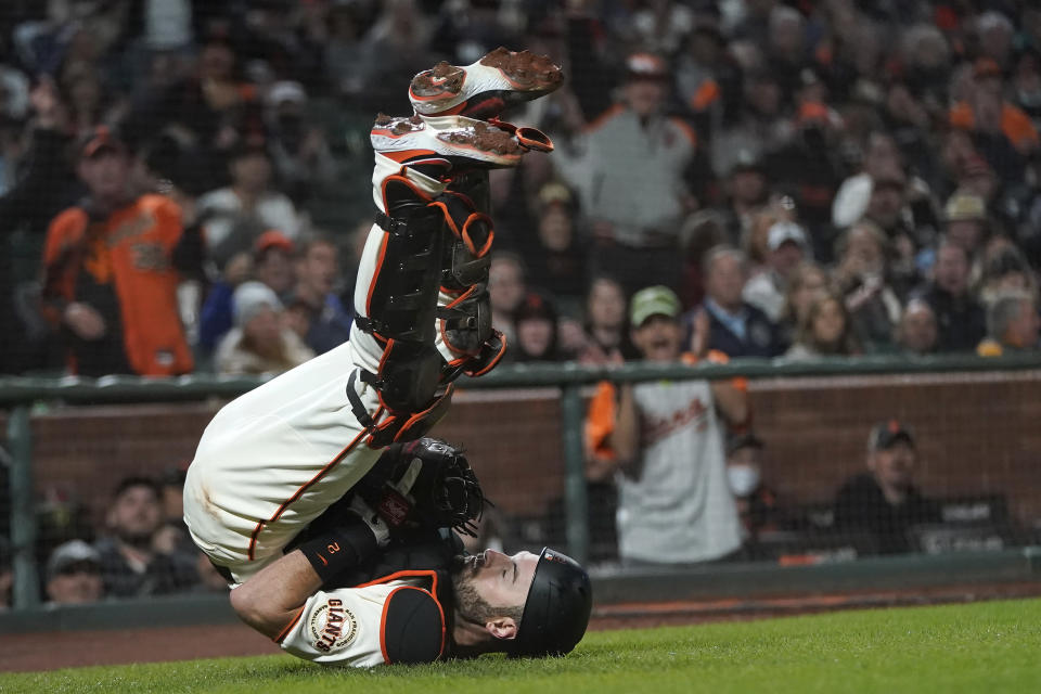 San Francisco Giants catcher Curt Casali falls backward after catching an out in foul territory hit by San Diego Padres' Fernando Tatis Jr. during the eighth inning of a baseball game in San Francisco, Monday, Sept. 13, 2021. (AP Photo/Jeff Chiu)