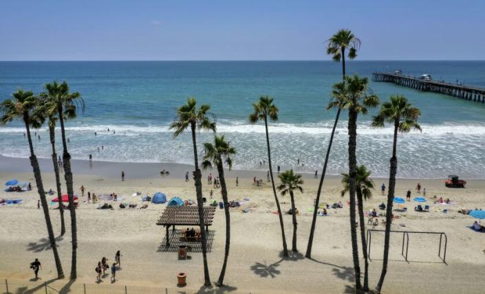 SAN CLEMENTE, CA - JUNE 30: Beach-goers take to the water on a warm summer day at the San Clemente Pier Tuesday, June 30, 2020. Heal the Bay released its annual Beach Report Card and the San Clemente Pier made the top 10 list of beach bummers. (Allen J. Schaben / Los Angeles Times)