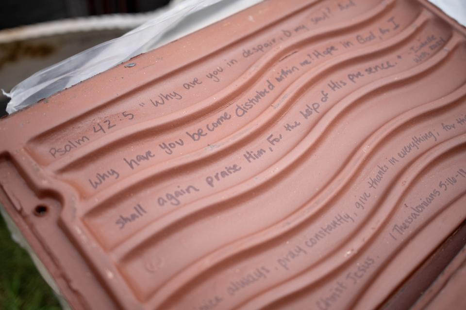 Oklahoma Baptist University students, staff and supporters wrote scripture, inspirational messages and their names on tiles that will be used for the new roof for the iconic Raley Chapel on the school's campus in Shawnee.