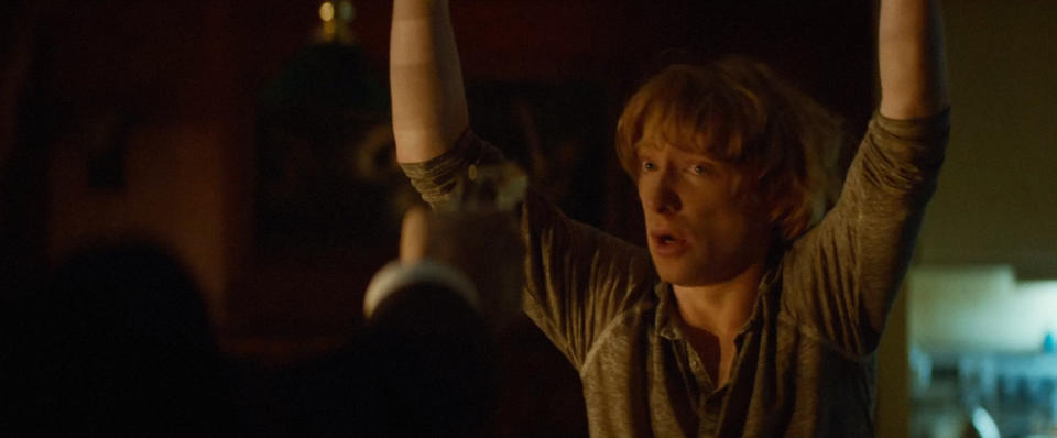 Domhnall Gleeson holds his hands up at gunpoint