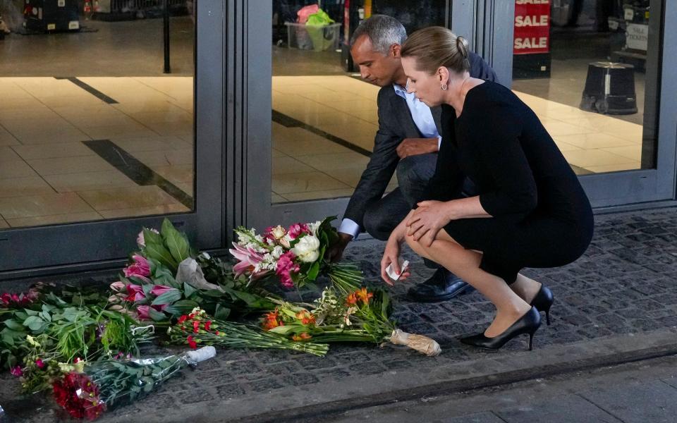 Mette Frederiksen, Denmark's prime minister, places flowers at the scene of the shopping centre in Copenhagen - AP Photo/Sergei Grits