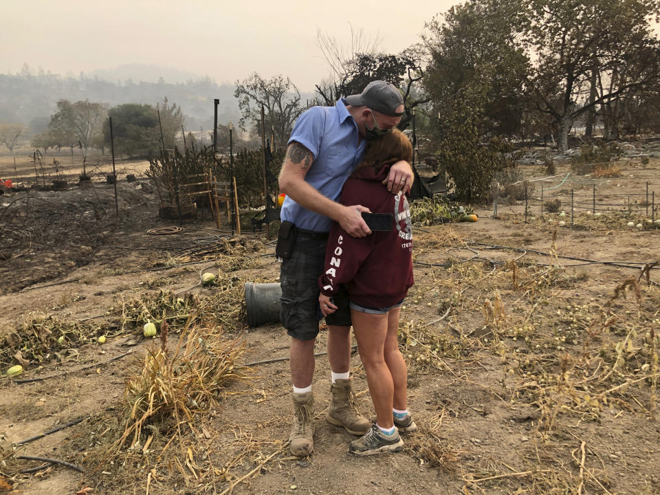 Kevin Conant and his wife, Nikki, hug after looking at the debris of their burnt home and business "Conants Wine Barrel Creations," after the Glass/Shady fire completely engulfed it, Wednesday, Sept. 30, 2020, in Santa Rosa, Calif. The Conants escaped with their lives, which we are grateful for, but they barely made it out with the clothes on their backs in the wake of the fire. The Glass and Zogg fires are among nearly 30 wildfires burning in California. (AP Photo/Haven Daley)