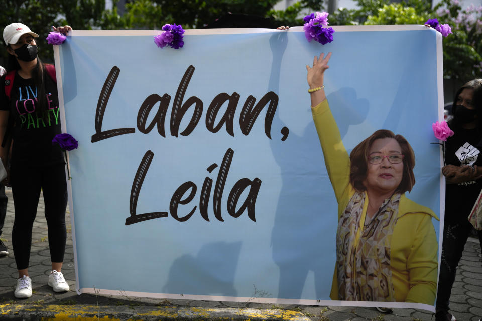 Supporters of detained former opposition Senator Leila de Lima hold slogans outside the Muntinlupa trial court on Friday, May 12, 2023 in Muntinlupa, Philippines. De Lima was acquitted by the Muntinlupa court in one of her drug related charges she says were fabricated by former President Rodrigo Duterte and his officials in an attempt to muzzle her criticism of his deadly crackdown on illegal drugs. (AP Photo/Aaron Favila)