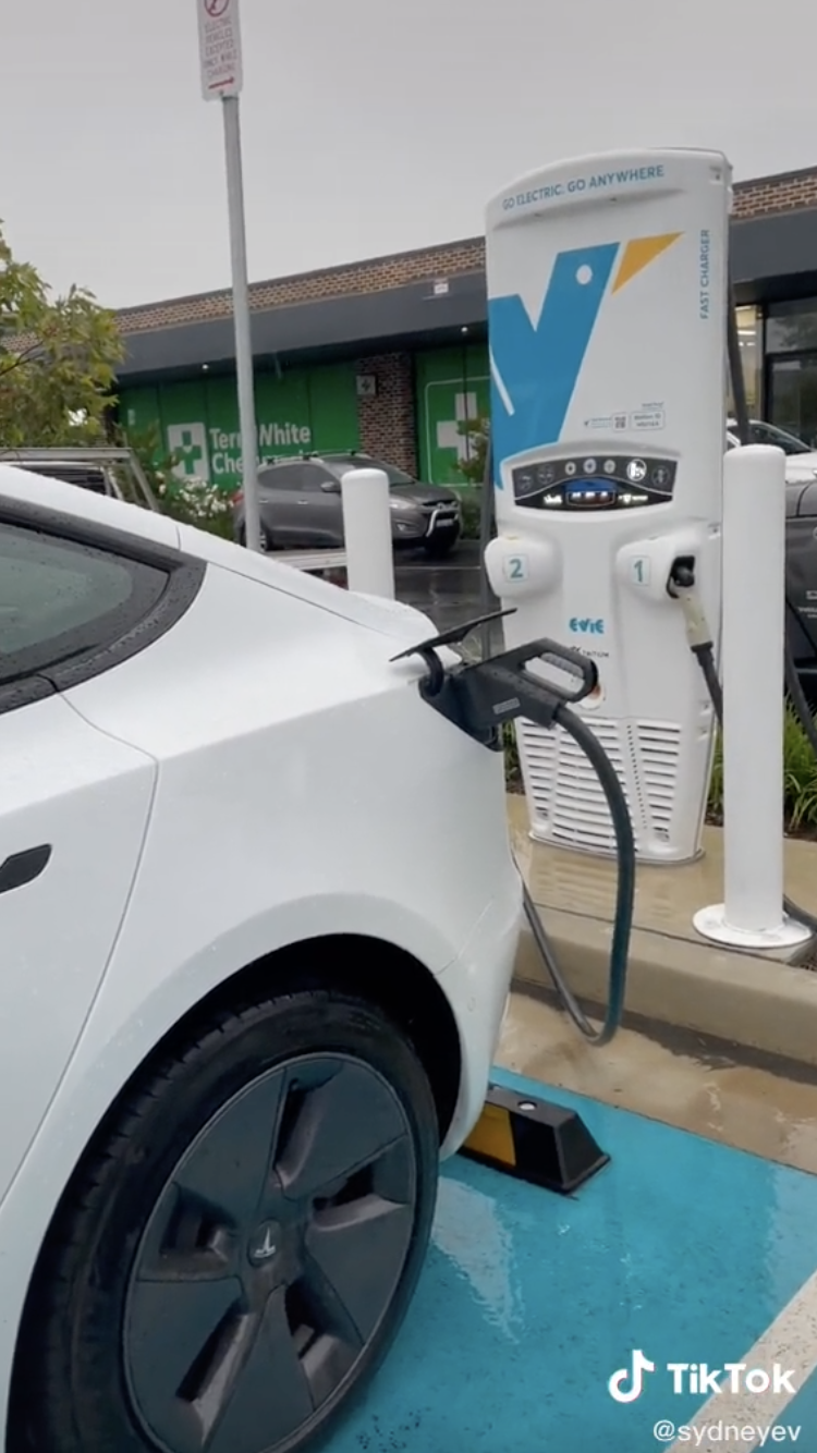 Screenshot of the TiKTok video showing an electric car station with a white car plugged in.