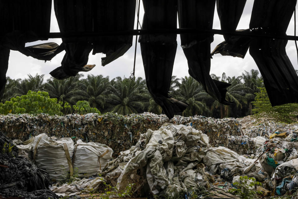 Plastic bales behind burned fencing at an illegal recycling site near Jenjarom, Malaysia, on Feb. 2. After China clamped down on imports of plastic scrap in 2018, Malaysia became the world&rsquo;s largest importer. (Photo: Joshua Paul for HuffPost)