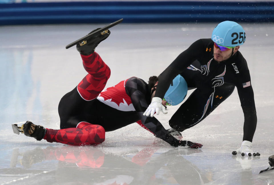 Eduardo Alvarez of the United States, right, and Charles Hamelin of Canada crash out in a men's 1000m short track speedskating quarterfinal at the Iceberg Skating Palace during the 2014 Winter Olympics, Saturday, Feb. 15, 2014, in Sochi, Russia. (AP Photo/Ivan Sekretarev)