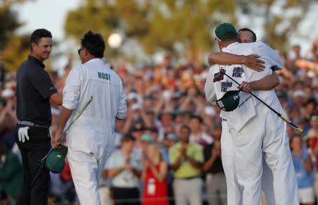 Sergio Garcia of Spain (R) hugs his caddie as Justin Rose of England greets his caddie after Garcia won the 2017 Masters golf tournament in a playoff at Augusta National Golf Club in Augusta, Georgia, U.S., April 9, 2017. REUTERS/Jonathan Ernst