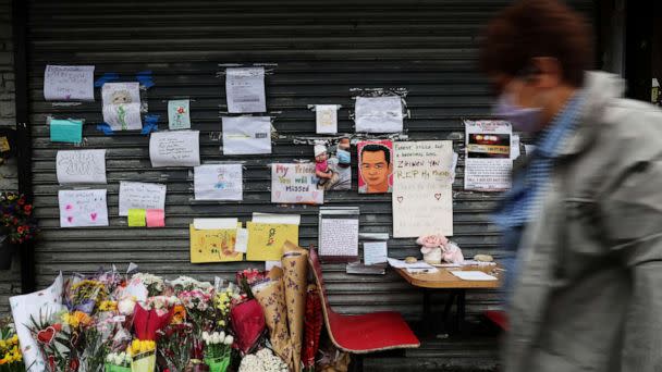 A person walks by a memorial for food delivery courier Zhiwen Yan,a 45-year-old Chinese immigrant fatally shot and killed on April 30, 2022, outside the Chinese restaurant where he worked in the Forest Hills neighborhood of Queens,New York on May 4, 2022. (Shannon Stapleton/Reuters)