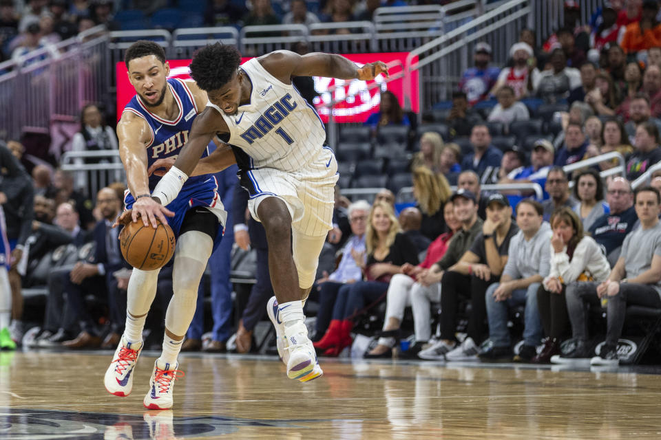 Philadelphia 76ers guard Ben Simmons (25) and Orlando Magic forward Jonathan Isaac (1) fight for the ball during the second half of an NBA basketball game in Orlando, Fla., Friday, Dec. 27, 2019. (AP Photo/Willie J. Allen Jr.)