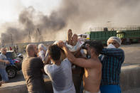 People evacuate a wounded person after a massive explosion in Beirut, Lebanon, Tuesday, Aug. 4, 2020. (AP Photo/Hassan Ammar)