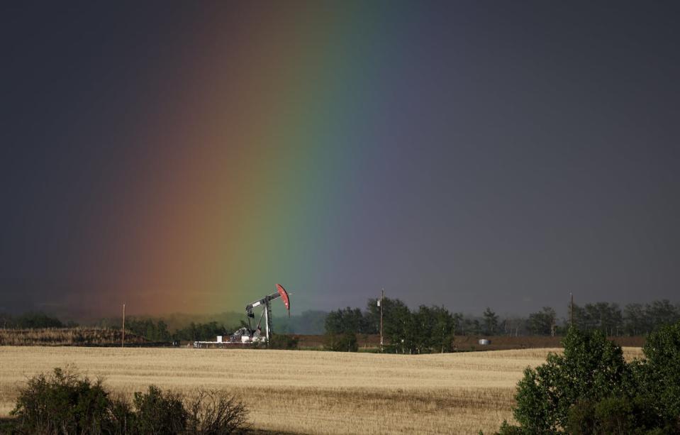 A pumpjack draws out oil and gas from a well head as a rainbow shines down on it near Calgary, in May 2023. THE CANADIAN PRESS/Jeff McIntosh