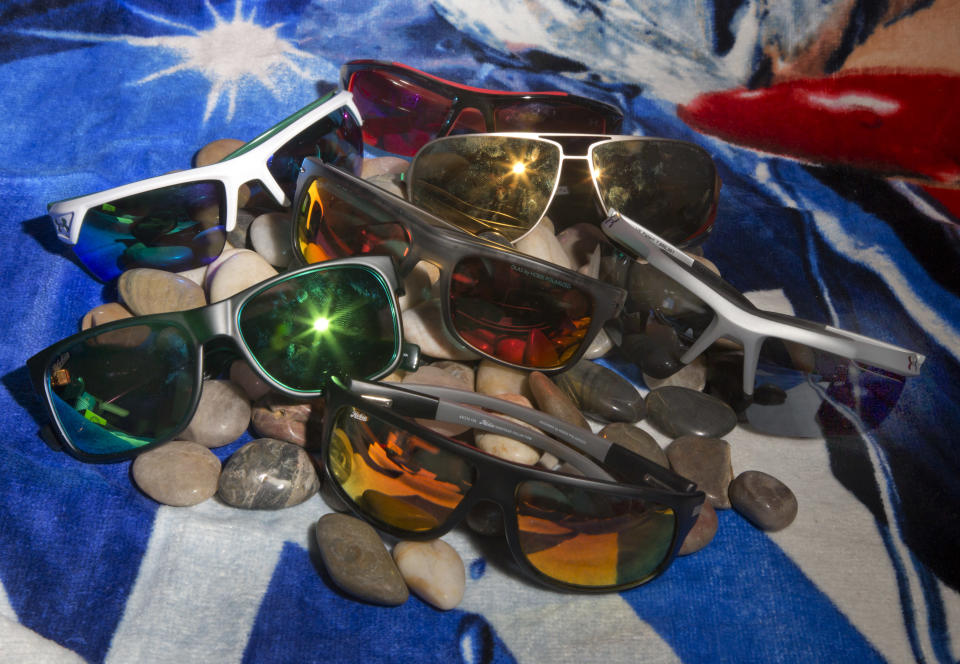 This June 18, 2013 photo shows a selection of sunglasses from Hobie and Under Armour in New York. Choosing new summer shades is more than an issue of flattering frames. There are decisions to be made about the lenses, too, and there will only be more in the future. (AP Photo/Richard Drew)