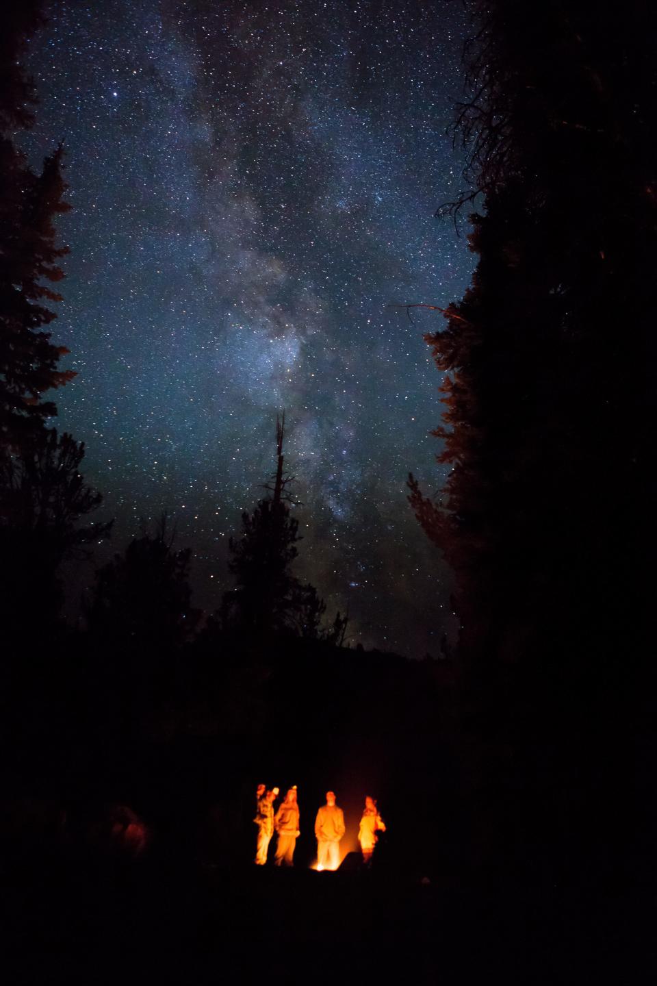 starry sky in jackson hole wyoming with bonfire in the bottom