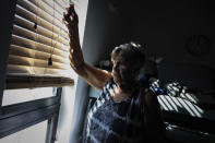 Barbara Wasko looks out the window of the sanctuary of the Southwest Baptist Church in Fort Myers, Fla., on Sunday, Oct 2, 2022. She took refuge inside the church when Hurricane Ian swept through Southwest Florida. (AP Photo/Robert Bumsted)