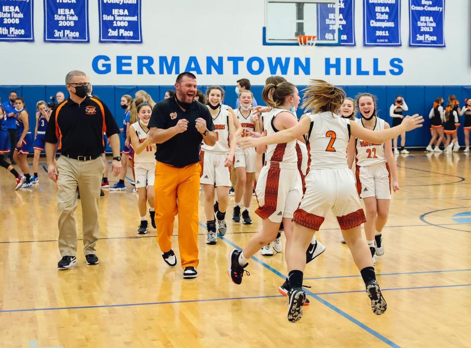 Washington Middle School eighth-grade girls basketball coach Reggie Durchholz (wearing orange pants) and his players are excited about winning the IESA Class 8-3A state championship.