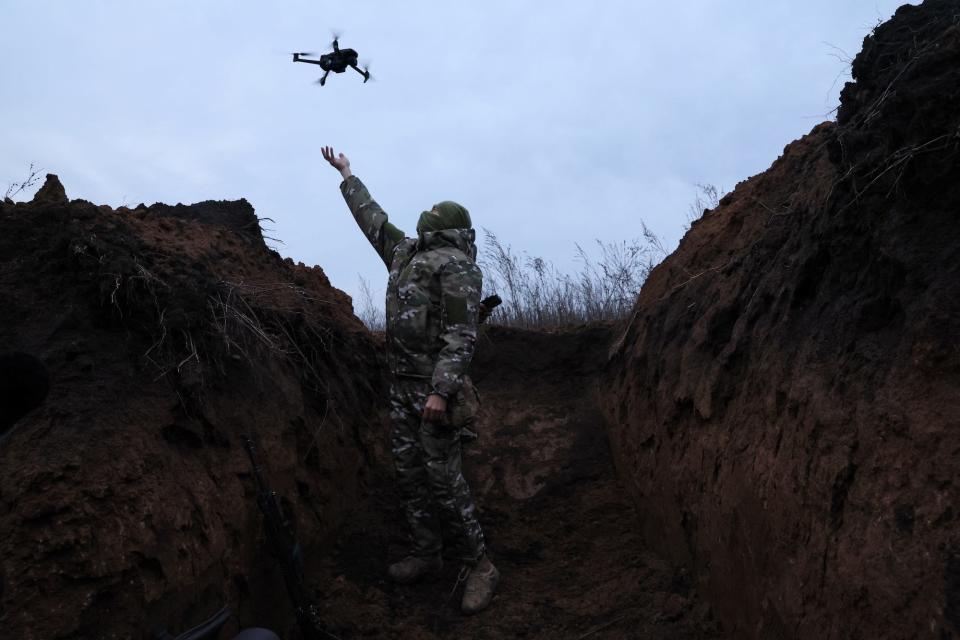 A soldier with Ukraine's 58th Independent Motorized Infantry Brigade catches a drone while testing it in a trench