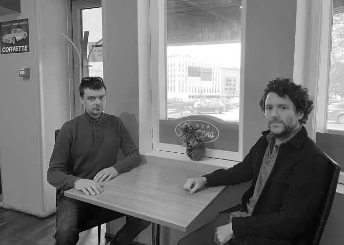 Artem Zinchenko and Yahoo News journalist Michael Weiss at a table in a cafe.