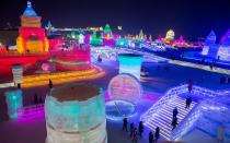 <p>People visit ice sculptures illuminated by colored lights at the Harbin Ice and Snow Festival to celebrate the new year.</p>